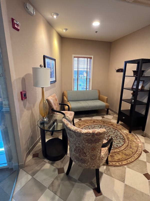 Relaxation area with checkered flooring and plush seating for patients