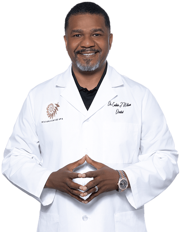 Dr. Calvin Wilson, founder of Wilson Dental Spa, smiling in a lab coat