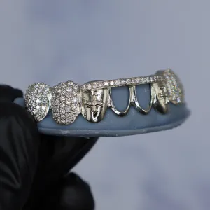 Custom white gold open-face bottom grillz with large pavé diamond dome caps on the outer molar positions, shown from the side on a dental cast