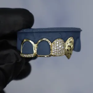 Custom yellow gold 4-tooth bottom grillz: two open-face caps, one fully pavé diamond cap, and one pointed diamond-cut fang cap, shown on a dental mold