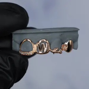 Custom rose gold 3-tooth gap filler grillz: an open-face oval cap with diamond-trim edge, an engraved letter W cap, and a rose with stem and leaf cap, shown on a dental mold